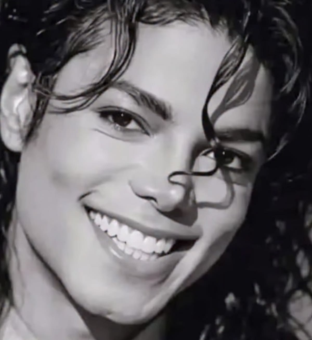 Black and white portrait of Michael smiling radiantly