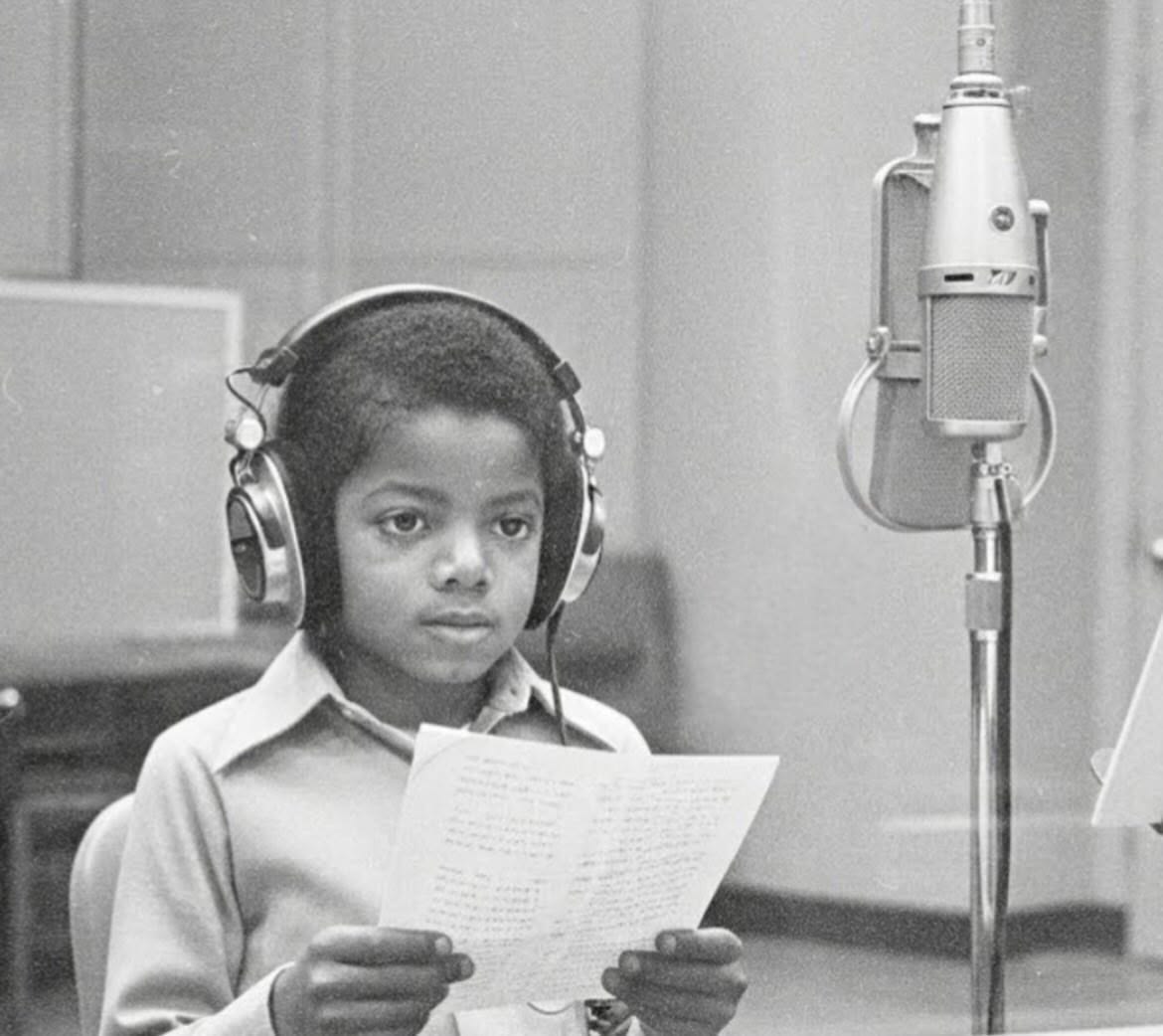 Michael as a child, singing at a studio microphone