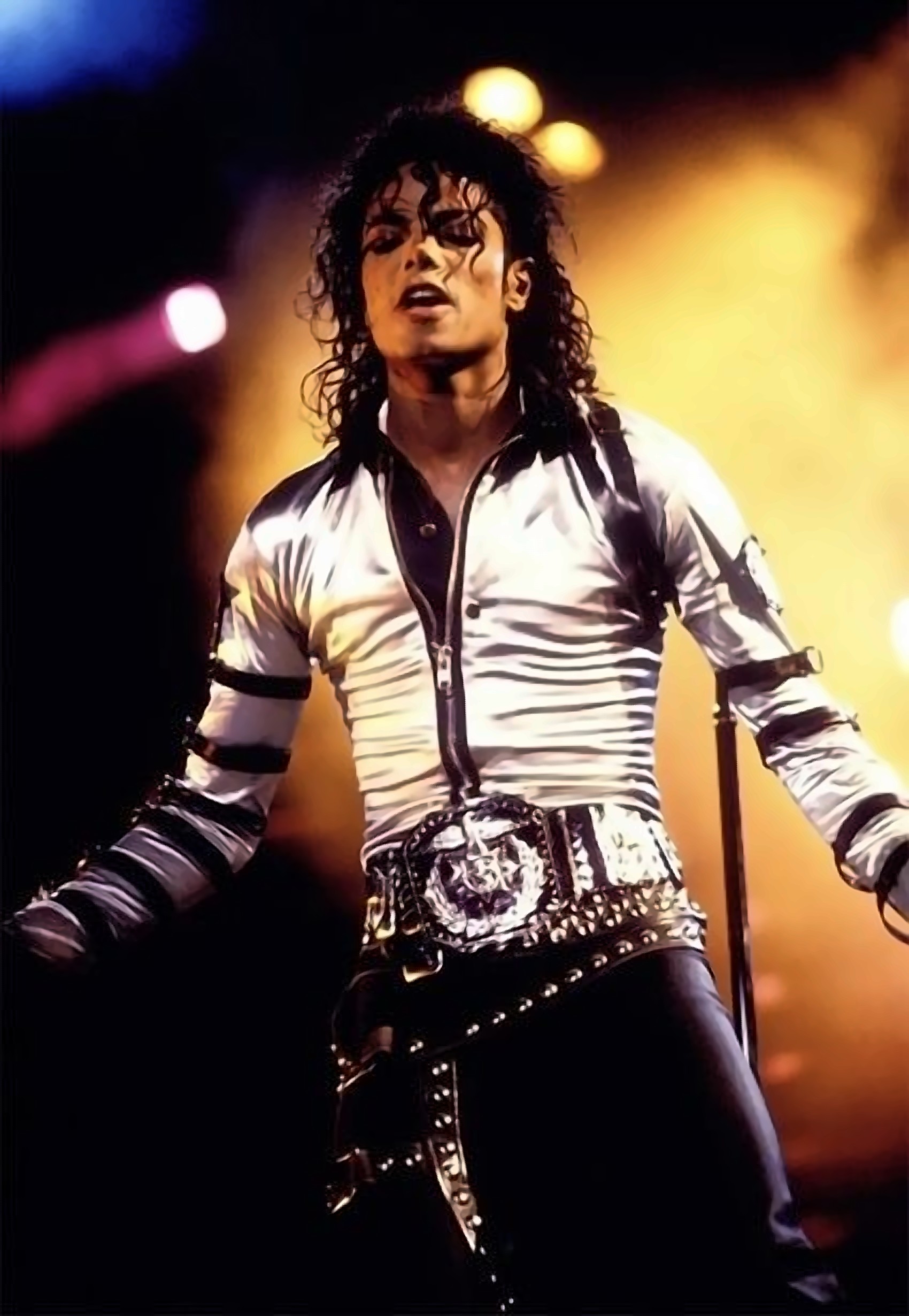 Michael Jackson on stage during the Bad Tour, silver shirt glowing under warm stage lights