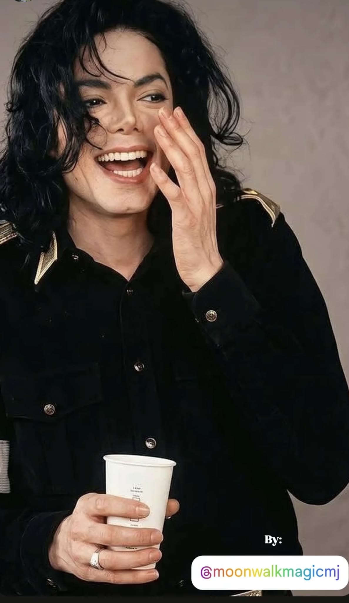 Michael laughing warmly, hand over his mouth